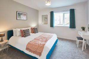 a bedroom with a bed and a desk and a window at Host & Stay - Endeavour Apartments in Whitby
