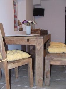 uma mesa de madeira com duas cadeiras e uma mesa com flores em Appartement Veronika em Öblarn
