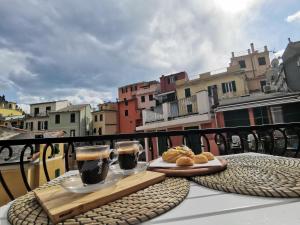 a table with two glasses of coffee and pastries on a balcony at SeaBreeze Vernazza in Vernazza
