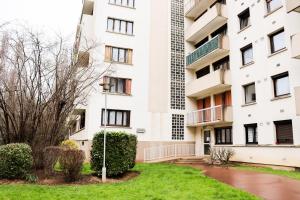 Un edificio de apartamentos con césped delante. en Appartement Plage et JACUZZI Balnéothérapie Athis Mons, en Athis-Mons