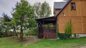 ein großes Holzhaus mit einer großen Terrasse in der Unterkunft Drewniany dom nad starorzeczem Narwi in Pianki