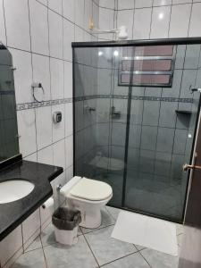uma casa de banho com um WC e uma cabina de duche em vidro. em Bravo City Hotel Nova Mutum em Nova Mutum