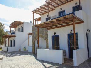 un edificio con paredes blancas y puertas azules. en Almiriki Serifos, en Livadakia