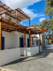 una casa con una pérgola de madera en el lateral en Almiriki Serifos, en Livadakia