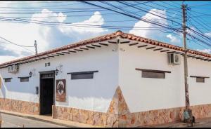a white building with a black door on a street at Hotel Boutique Casa Grande in Piedecuesta