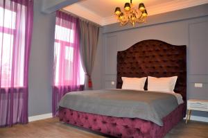 a bedroom with a large bed with pink curtains at Kiev City Center in Kyiv