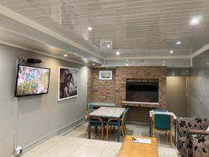 a living room with a table and a fireplace at Hirondelle @ 45 Old Paarl in Bellville
