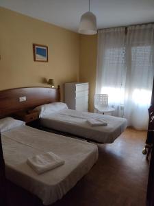a bedroom with two beds and a window at Hotel Camagüey in Gijón +23 photos