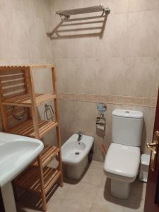 a bathroom with a toilet and a sink at Hotel Camagüey in Gijón