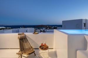 a wooden chair sitting on top of a white building at TinosVillages in Tinos