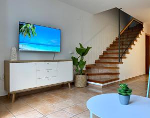 a living room with a tv and a staircase at Gust De Sal in Denia