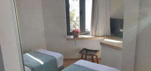 a bathroom with a window and a table and a chair at Blueonar in Chania Town