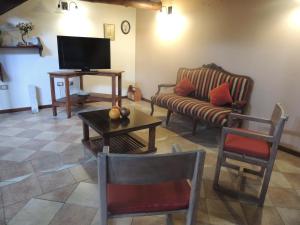 a living room with a couch and a tv at Jardín de Iris in Maipú