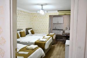 Habitación de hotel con 4 camas y cocina en ada hotel, en Estambul