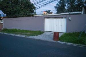 una puerta de garaje blanca al lado de una casa en Hostal Mision Catracha, en Tegucigalpa