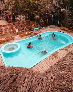 três pessoas numa piscina com WC em El Zoo Hostel, Bar & Pool em Palomino