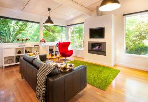 a living room with a black couch and a red chair at The Gallery Olinda in Olinda