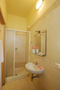 uma casa de banho com um lavatório e um chuveiro em Hotel Caggiari em Senigallia