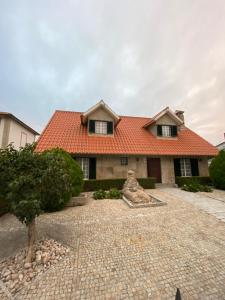 une maison avec un toit orange dans une allée en briques dans l'établissement Giravillage, à Girabolhos