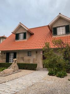 une maison avec un toit orange et une allée en pierre dans l'établissement Giravillage, à Girabolhos 15 autres photos