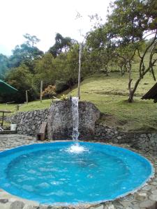 a small pool with a waterfall in a yard at Casa Yantra La Lola in Pance
