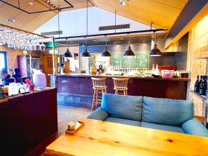 a restaurant with a blue couch and a bar at White Space in Kakegawa