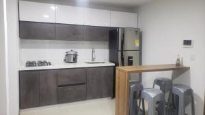 a kitchen with a stove and a refrigerator at Apartamento vacacional FL Martinz in Manizales