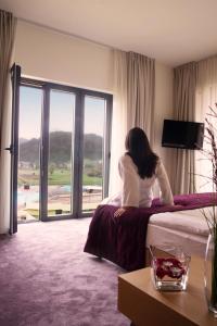 een vrouw op een bed in een hotelkamer bij Terme Tuhelj Hotel Well in Tuheljske Toplice