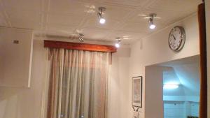 ブカレストにあるRomPromo Plus Accommodationの天井時計とカーテン付きの部屋