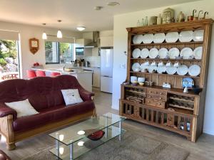 a living room with a couch and a table at Sunset Point Kerikeri in Kerikeri