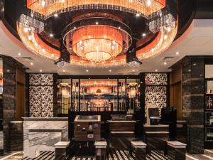 a lobby with a large chandelier and a bar at APA Hotel Osaka Temmabashi-Ekimae in Osaka