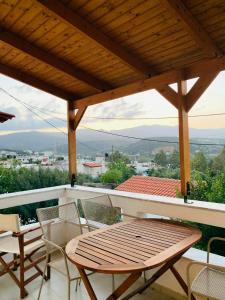 y balcón con mesa y sillas de madera. en Almira sea view Appartment en Istron