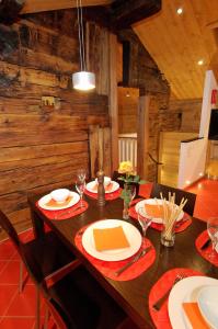 une salle à manger avec une table en bois, des assiettes et des verres dans l'établissement Ferienapartement Hinterdorf, à Zermatt
