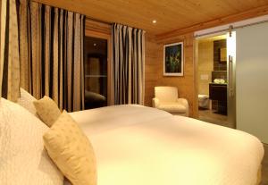 1 dormitorio con 1 cama blanca y 1 silla en Ferienapartement Hinterdorf, en Zermatt