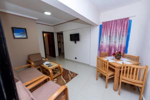 a living room with a table and chairs and a television at Noras Beach Hotel in Port Said