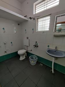 a bathroom with a toilet and a sink at Yoga House in Vānivilāsa Puram