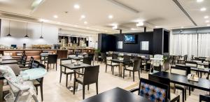 a restaurant with black tables and chairs and a bar at Holiday Inn Express Dubai, Jumeirah, an IHG Hotel in Dubai