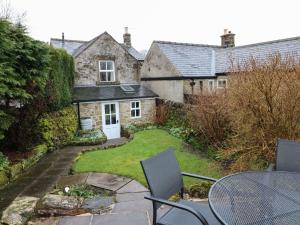 an outside view of a house with a table and chairs at Walton Cottage in Winster