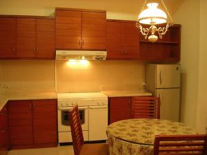 een keuken met een wit fornuis en een tafel met stoelen bij Margot Apartment Pondok Indah in Jakarta