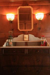 two lights on top of a dresser with a mirror at Heidi's Guesthouse in Frenières