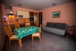 a kitchen and a living room with a table and a couch at Apartments Masera in Kobarid