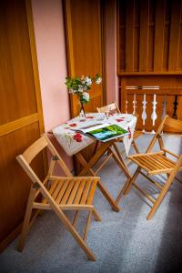 a table with two chairs and a table with flowers on it at Apartments Masera in Kobarid
