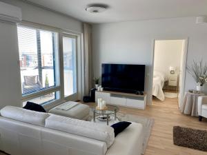 a living room with a white couch and a flat screen tv at The River 31, Baritoni in Pori