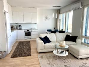 a living room with a white couch and a table at The River 31, Baritoni in Pori