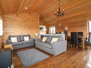 a living room with two couches and a dining room at Holly Lodge in Bodmin