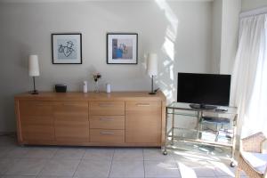 uma sala de estar com uma televisão em uma cômoda de madeira em Mirage em Ostend