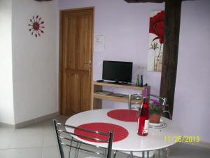 a dining room with a white table and a television at Appartement Larraburuko-Borda in Sare