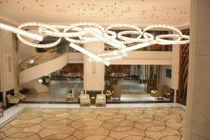 a lobby with a large chandelier in a building at Midan Hotel & Suites Al Aziziya in Makkah