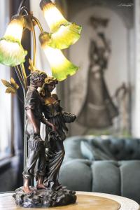 歐雷提亞達的住宿－韋恩尼酒店，一张桌子上拿着一盏灯的两个人的雕像