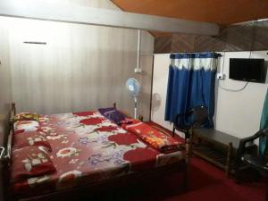 a bedroom with a bed with a red comforter at RAOJI Home Stay in Vālpārai